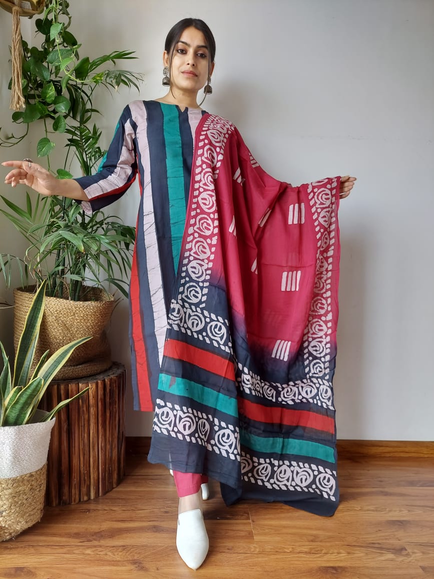 Woman holding a colorful patterned scarf in a room with plants